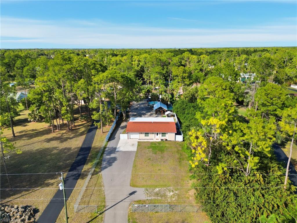 Single-story residence with an orange tile roof, situated on a lot with mature trees
