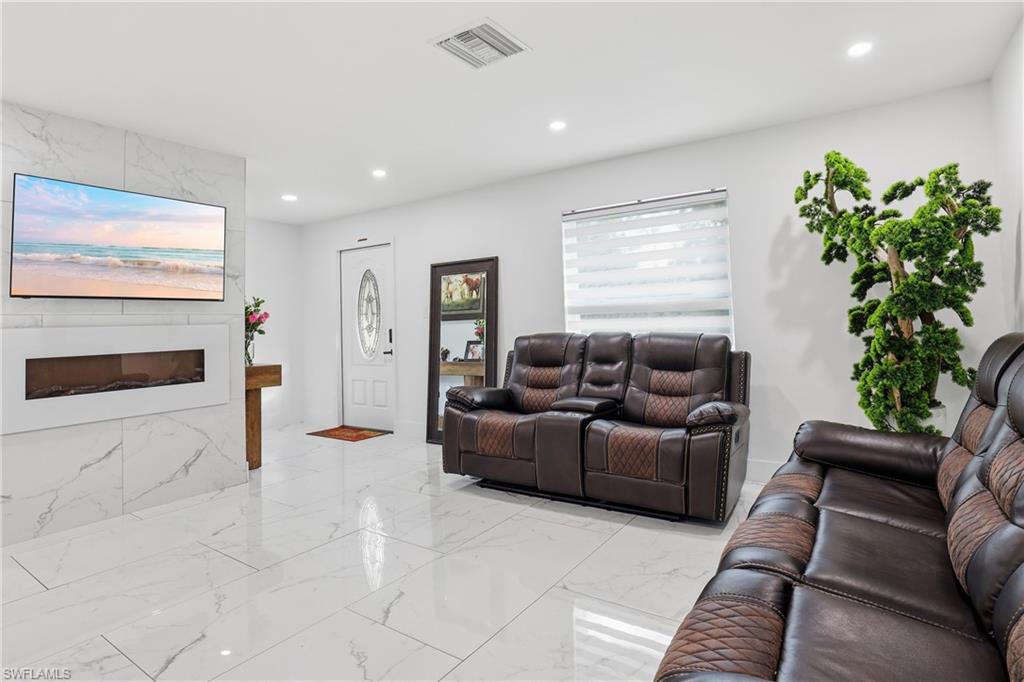 White tile flooring, white walls, recessed lighting, and a white entry door with an oval glass insert