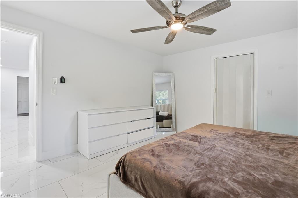 White tile flooring, ceiling fan with integrated lighting, and white walls