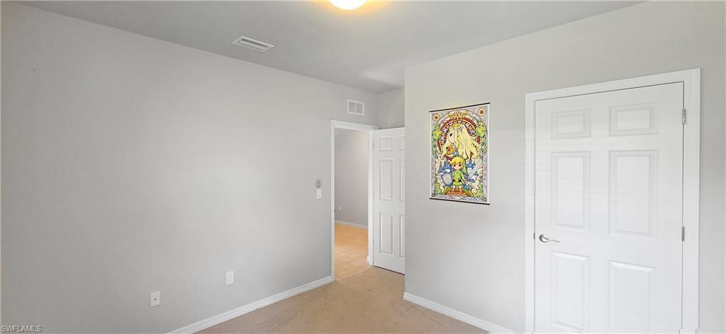 Bright secondary bedroom featuring neutral wall finishes, wood-finish flooring, and abundant natural lighting