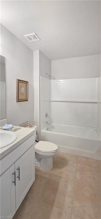 Bathroom featuring a white subway tile shower surround, a white bathtub, and a single vanity with white cabinetry and a white countertop