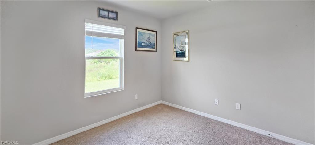 Light gray wall color with white baseboards and neutral carpet flooring