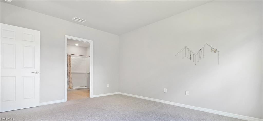Carpeted room featuring light gray walls, white trim, and a white paneled door