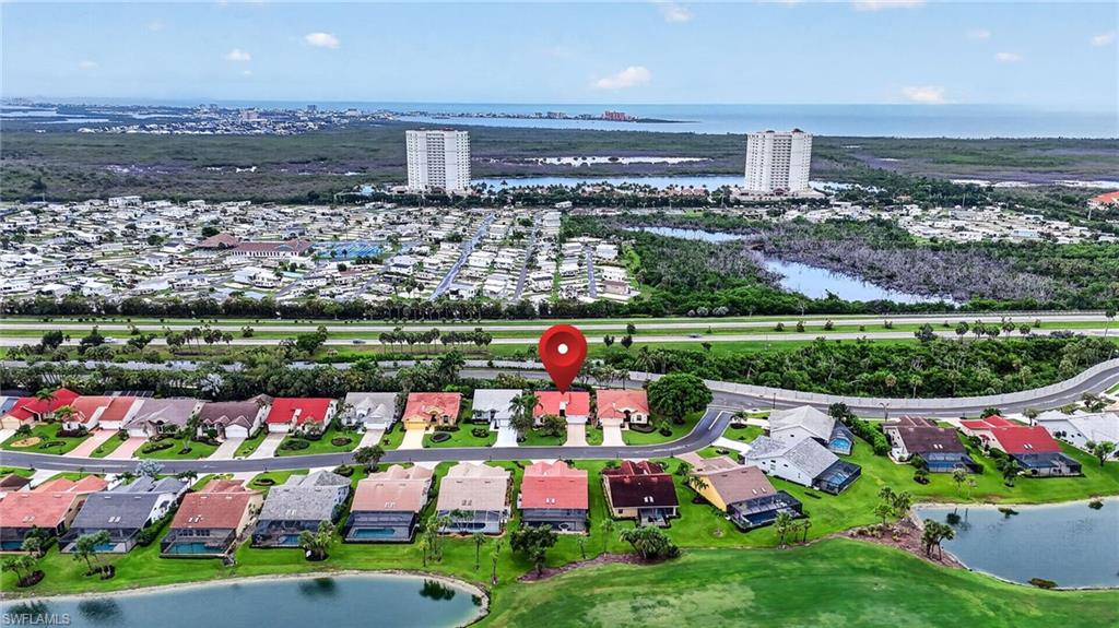 Aerial perspective of a residential community featuring single-story homes with individual driveways and manicured lawns