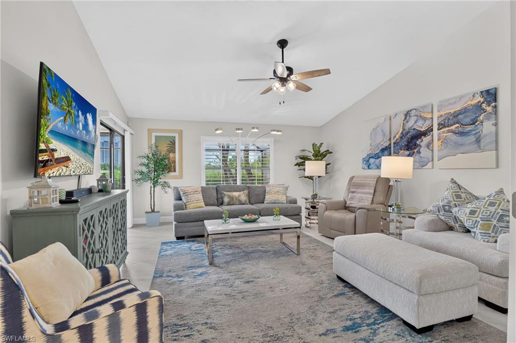 Spacious living area featuring light-toned walls and wood-finish flooring