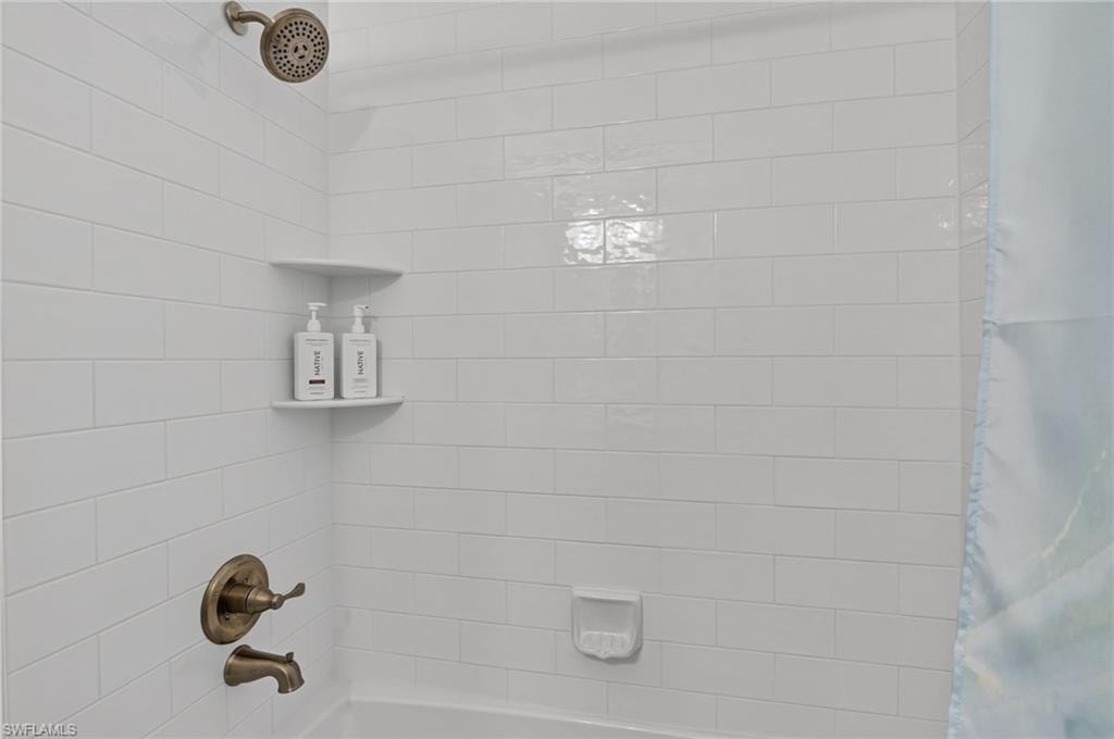 Subway tile shower surround with integrated corner shelves and bronze fixtures