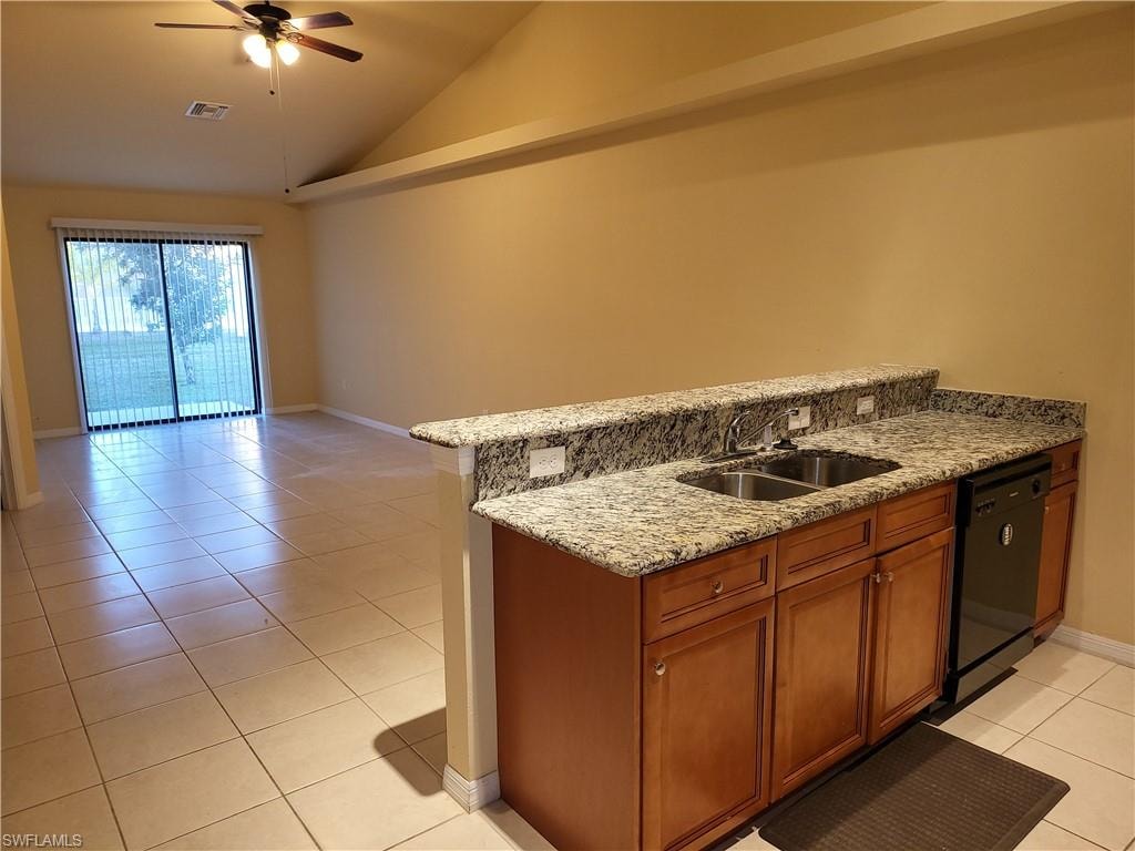 Kitchen featuring black dishwasher, brown cabinetry, vaulted ceiling, a sink, and light tile patterned flooring