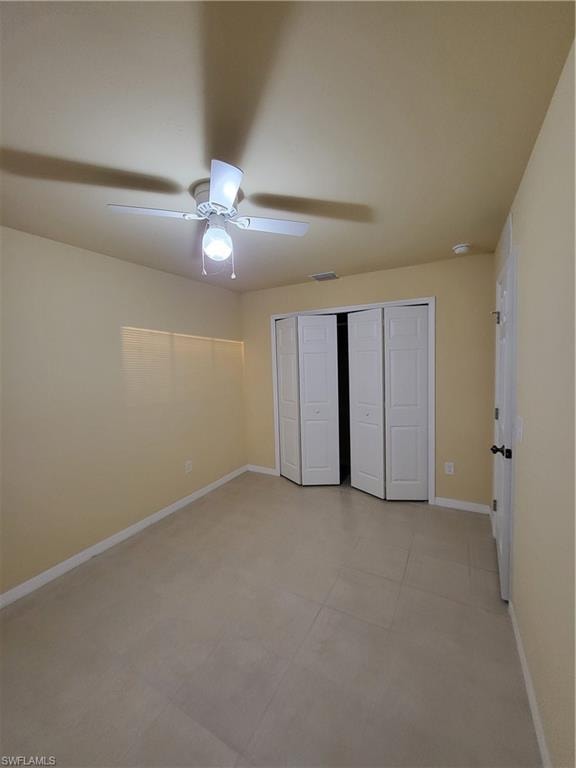 Unfurnished bedroom featuring a ceiling fan, a closet, visible vents, and baseboards