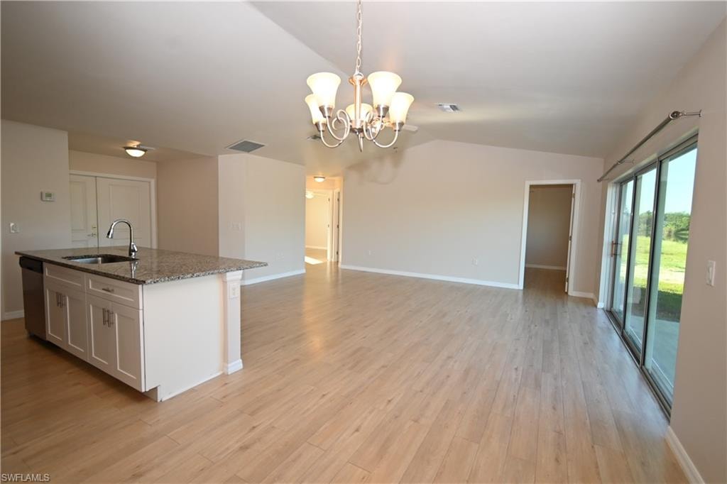 Kitchen island with granite countertop, stainless steel sink, and dishwasher