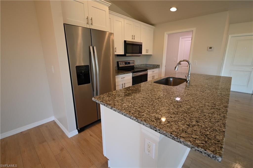 Kitchen island with a stainless steel sink and granite countertop, equipped with a chrome faucet