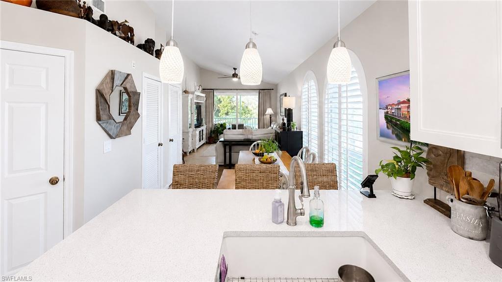 Arched windows with white louvered shutters, ceramic tile flooring, built-in shelving, and white louvered bi-fold doors