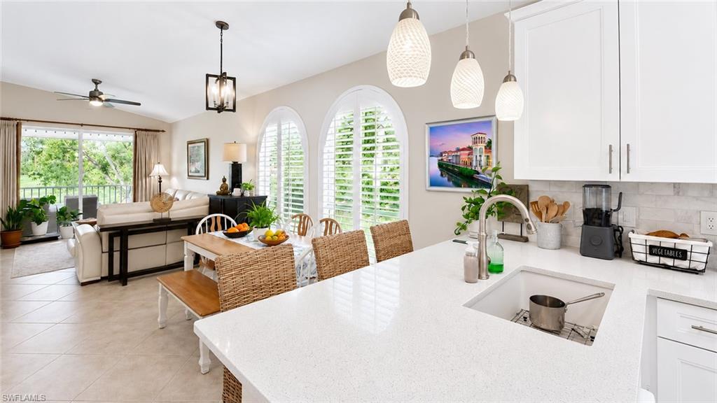 Kitchen featuring white cabinetry, pendant lighting, a built-in microwave, white countertops, and a ceiling fan
