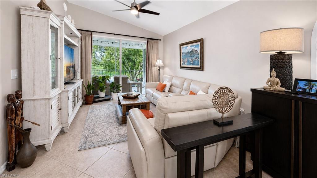 Vaulted ceilings, tile flooring, louvered bi-fold door, ceiling fan with integrated lighting, and sliding glass door with balcony access