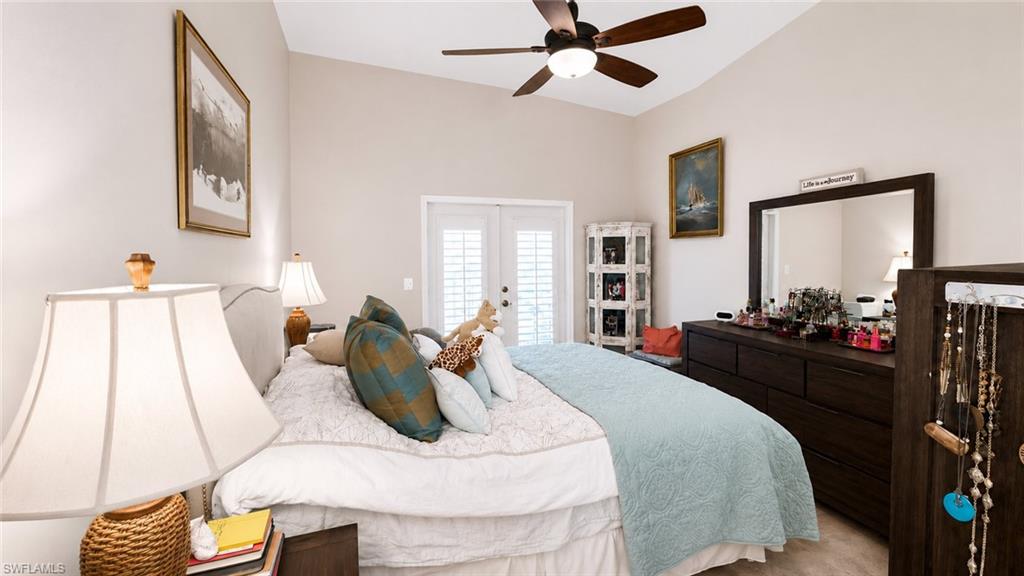 Vaulted ceiling with a ceiling fan, French doors with louvered blinds, and a built-in wall mirror
