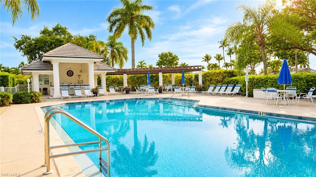 Rectangular swimming pool with a tile finish, integrated steps, and a stainless steel handrail