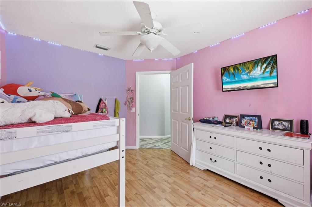 Interior room with wood-finish flooring and a white ceiling fan