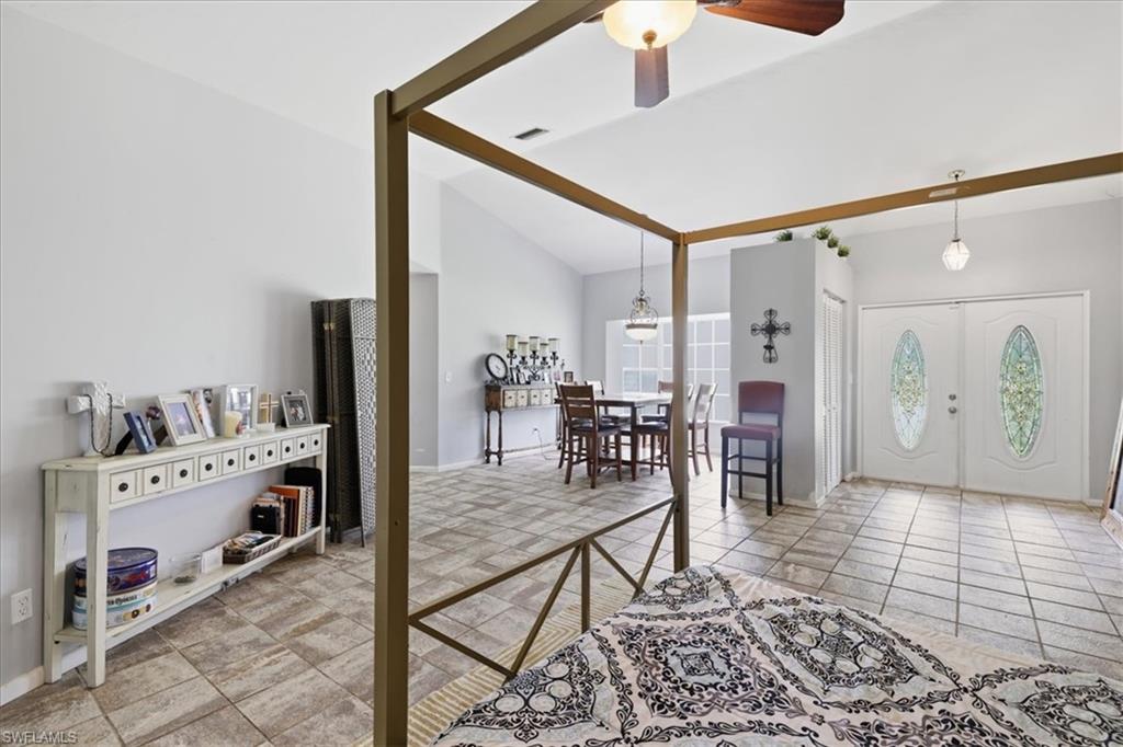 Vaulted ceilings accent an open living space featuring tile flooring throughout