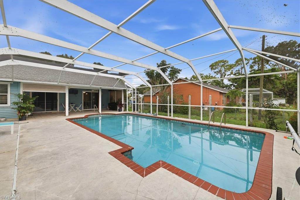 Resort-style swimming pool with crystal-clear water and custom brick decking, sheltered beneath a transparent polycarbonate enclosure