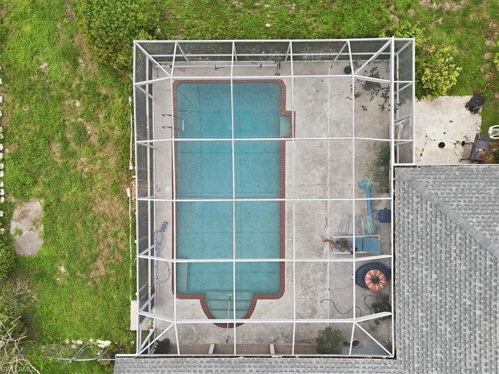 Screened pool enclosure with a rectangular swimming pool featuring integrated steps and a surrounding concrete deck