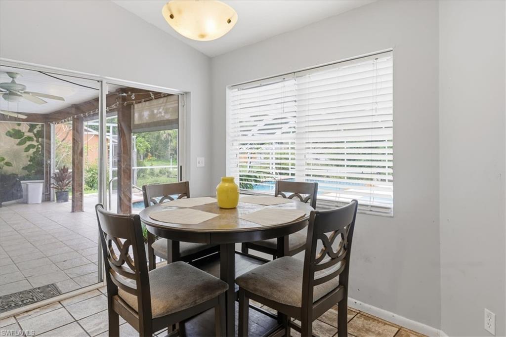 Dining area featuring a window with horizontal blinds and direct access to a screened patio