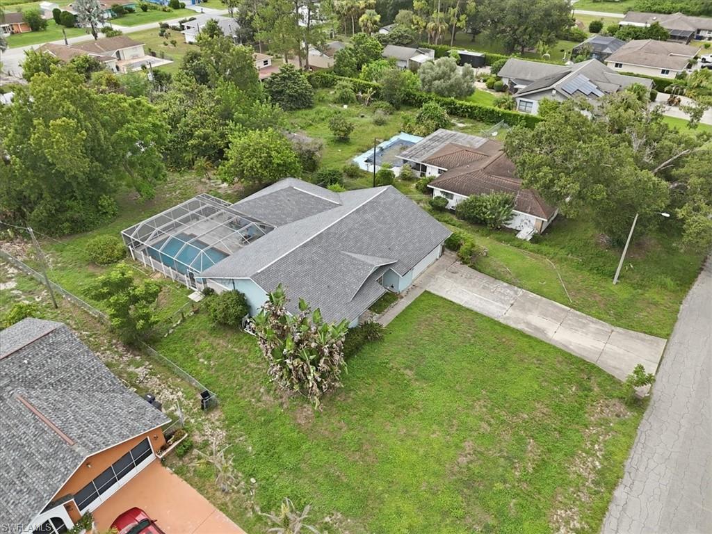 Single-story residence featuring a screened-in swimming pool, a concrete driveway, and a shingle roof