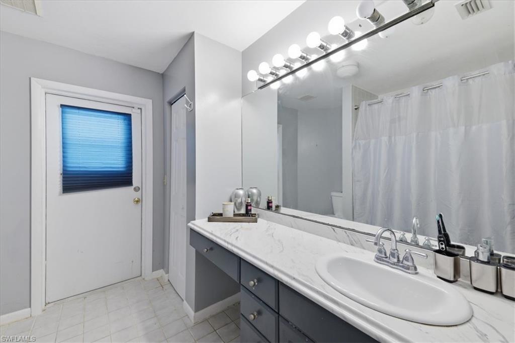 Bathroom featuring an oval undermount sink set into a white marble-look countertop