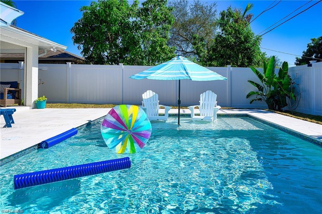 SOUTHERN EXPOSURE, FULLY FENCED, NEWER POOL with TANNING SHELF and LANDSCAPED BACKYARD