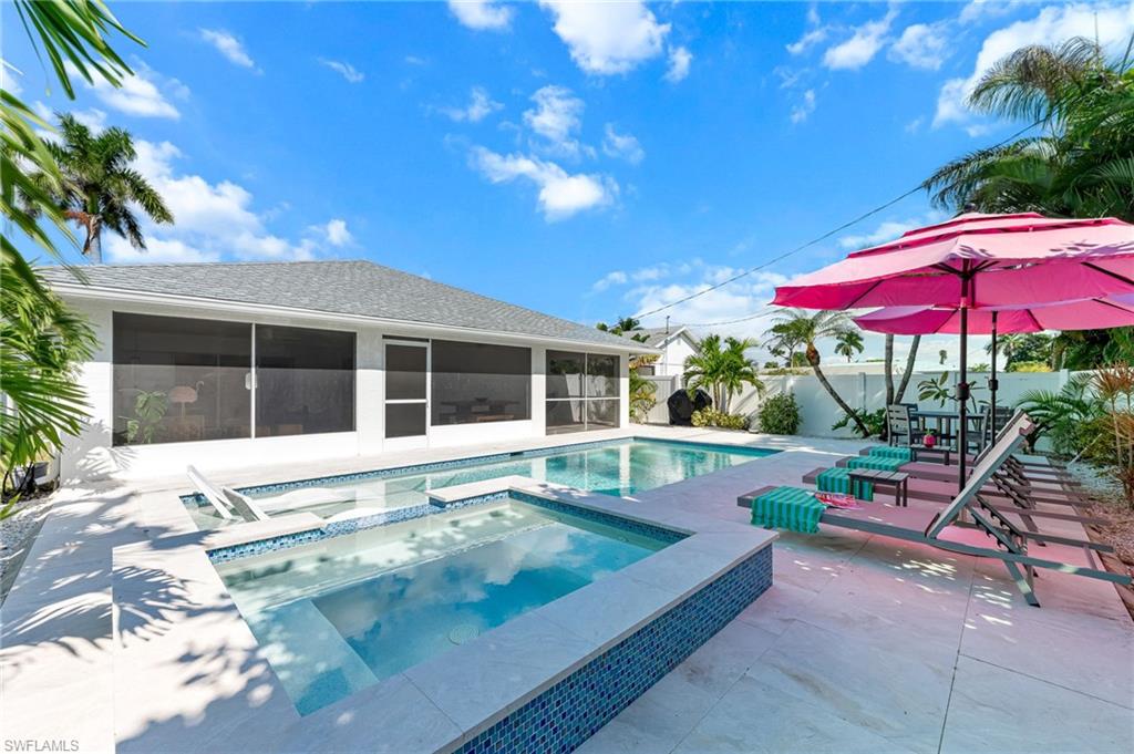 View of swimming pool with a sunroom, a patio, a pool with connected hot tub, and a fenced backyard
