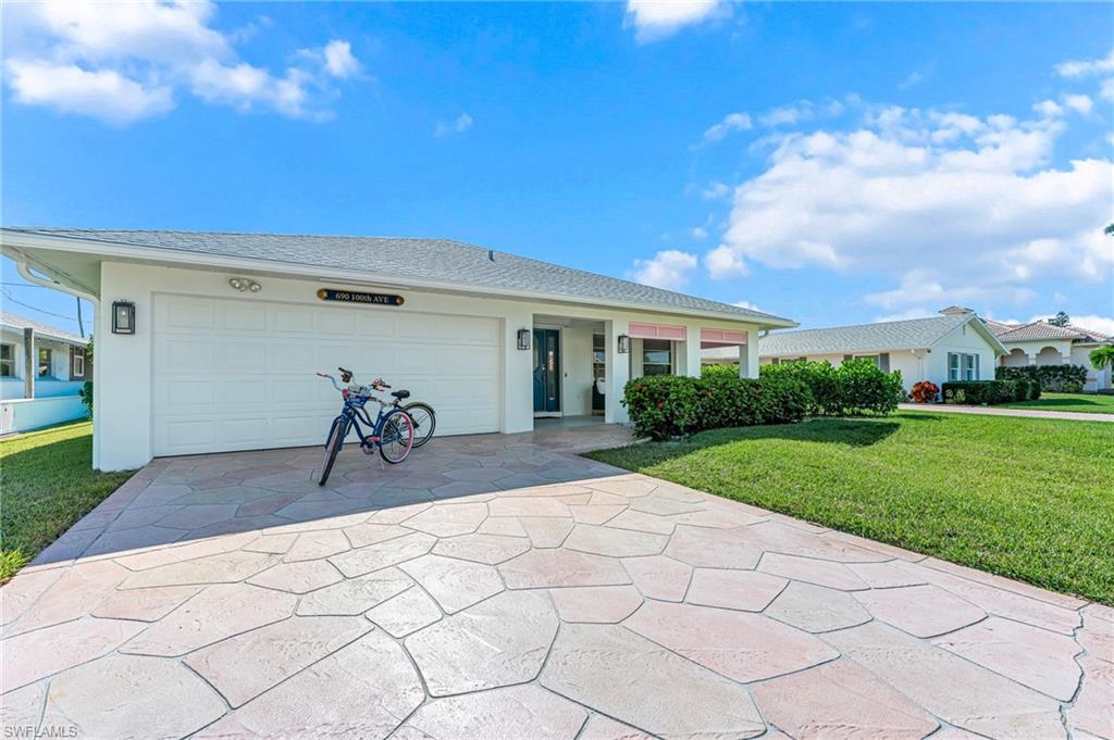 Single story home with a front lawn, concrete driveway, stucco siding, and an attached garage