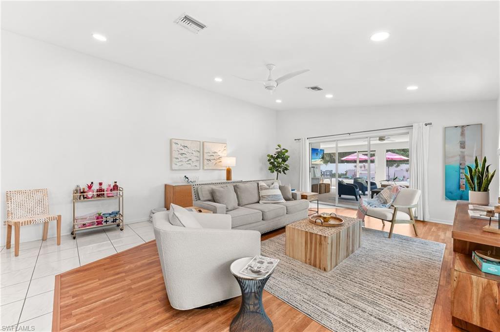Living room with vaulted ceiling, a ceiling fan, and recessed lighting