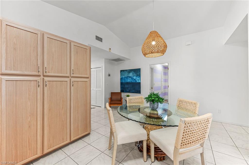 Dining space with vaulted ceiling and light tile patterned floors
