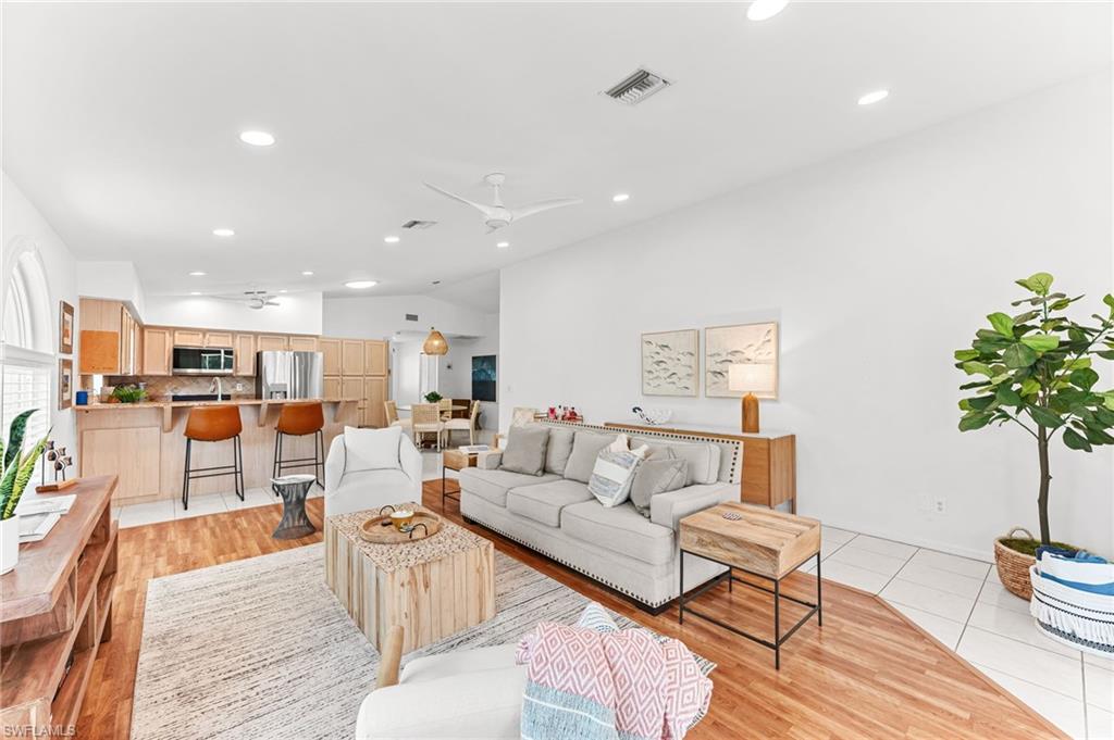 Living area featuring lofted ceiling, recessed lighting, a ceiling fan, and light tile patterned floors