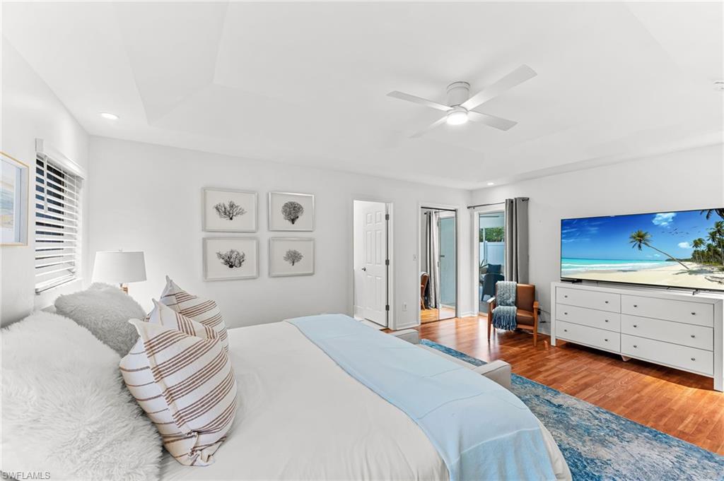 Bedroom featuring wood finished floors, ceiling fan, recessed lighting, and a raised ceiling