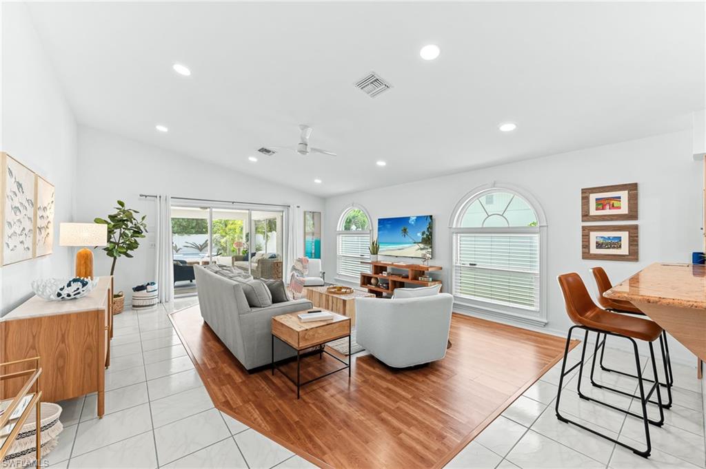 Living area with light tile patterned floors, healthy amount of natural light, recessed lighting, a ceiling fan, and vaulted ceiling