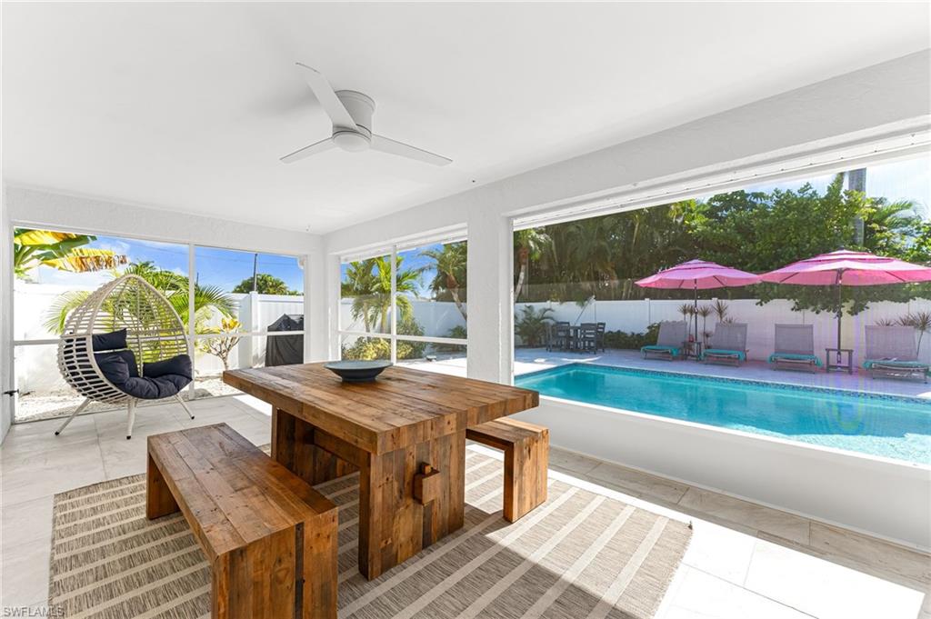 View of swimming pool featuring a fenced backyard, outdoor dining space, ceiling fan, a patio area, and a sunroom