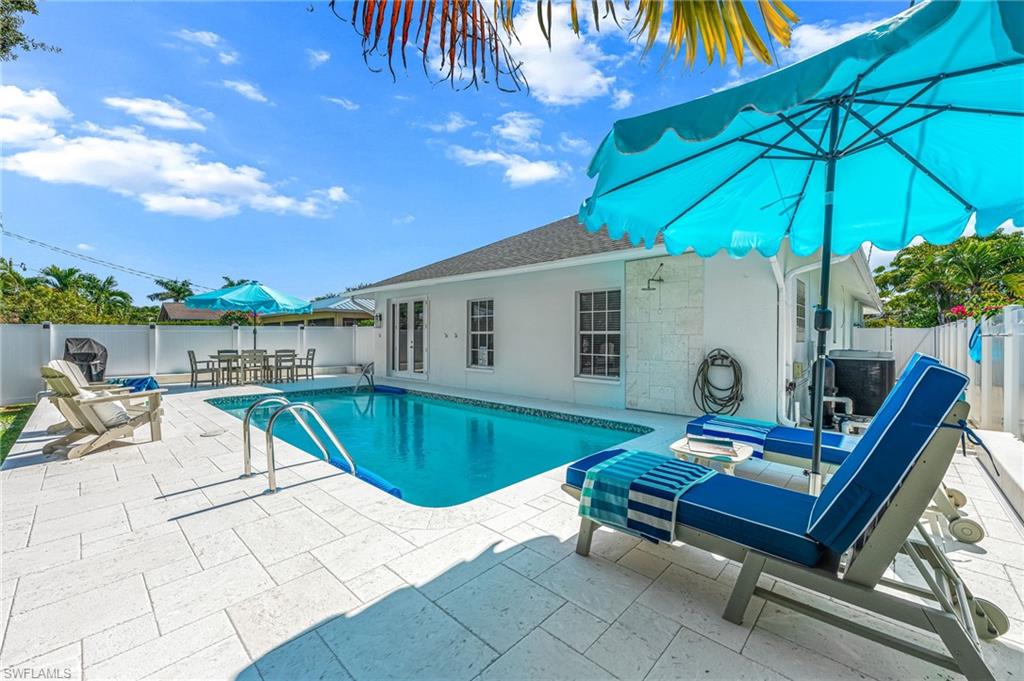 View of pool with a fenced backyard, a patio, and outdoor dining area