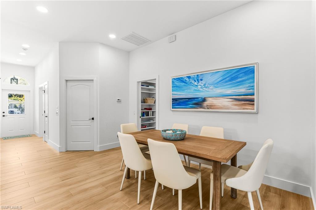 Dining room with light wood-type flooring and recessed lighting