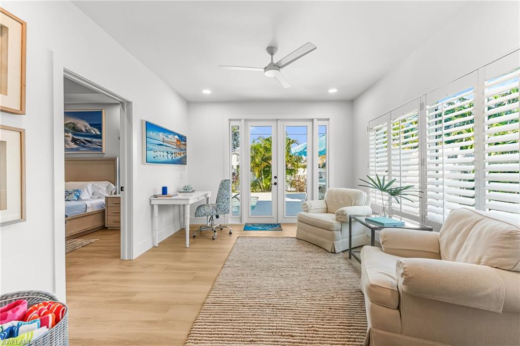 Living area with an office area, light wood finished floors, ceiling fan, french doors, and recessed lighting
