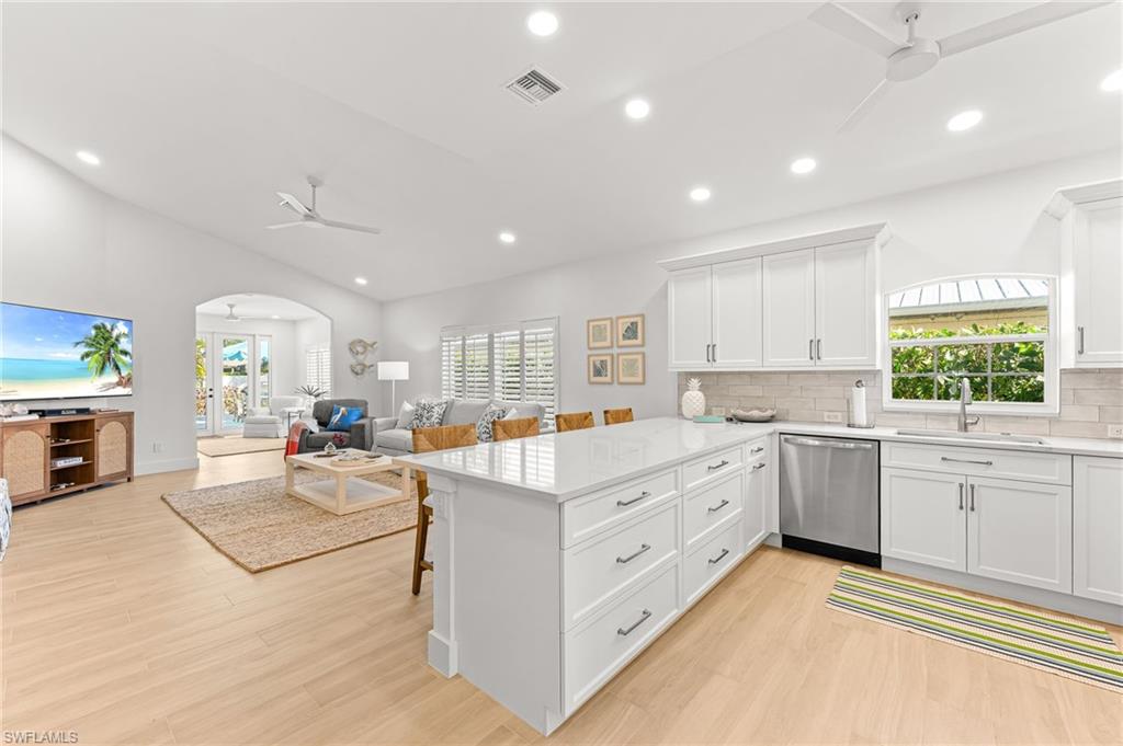 Kitchen with ceiling fan, a peninsula, recessed lighting, and white cabinets