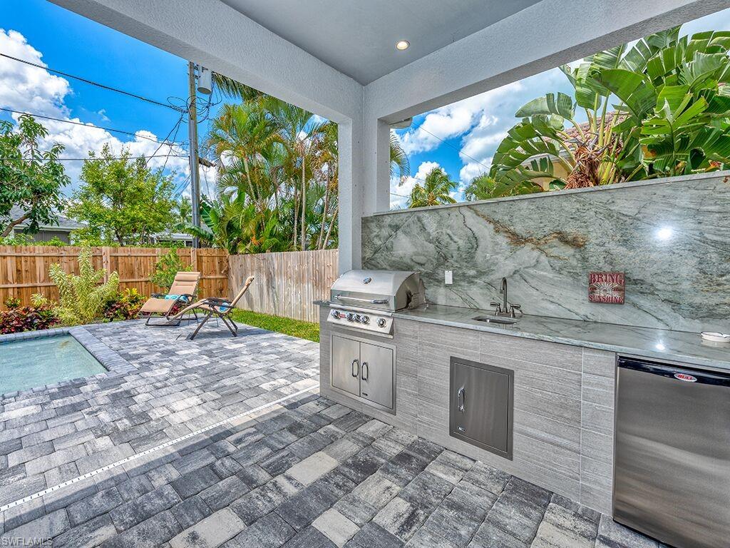 Fenced backyard with a patio and an outdoor kitchen