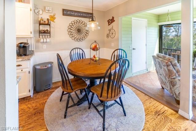 Wood-finish flooring, white cabinetry, light-toned walls, and a built-in light fixture