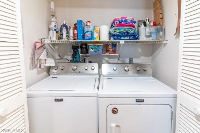 Laundry area featuring a top-load washer, front-load dryer, and an overhead wire shelf