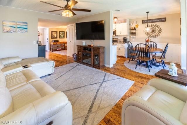 Wood-finish flooring throughout, with a ceiling fan featuring an integrated light fixture