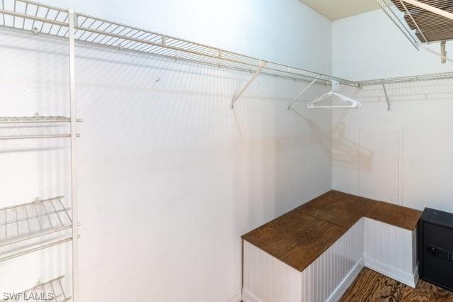 White wire shelving system, built-in L-shaped bench with wood-finish top, white beadboard paneling