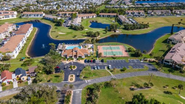 Community amenities featuring a central clubhouse, swimming pool, tennis courts, and golf course access, surrounded by multiple bodies of water