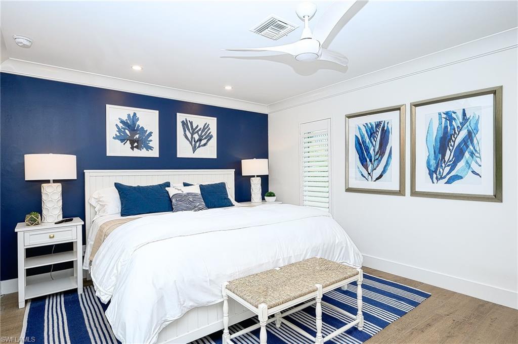 Bedroom with ornamental molding, ceiling fan, and hardwood / wood-style flooring
