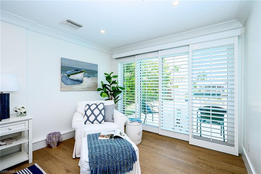 Living area featuring ornamental molding and hardwood / wood-style flooring