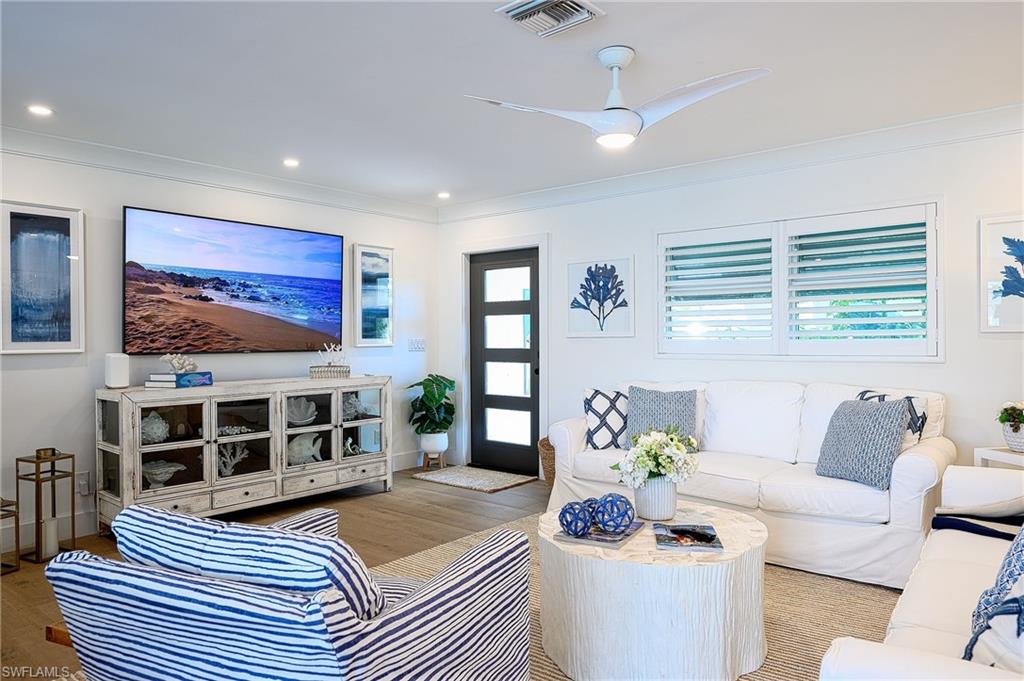 Living room featuring light hardwood / wood-style flooring, ceiling fan, and ornamental molding