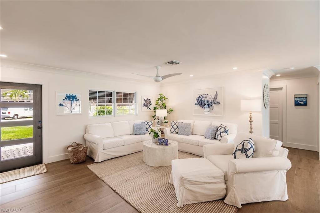Living room with a wealth of natural light, ceiling fan, and hardwood / wood-style flooring