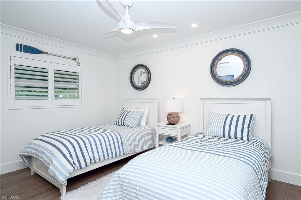 Bedroom featuring ornamental molding, dark wood-type flooring, and ceiling fan